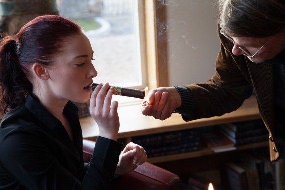 Sofie Andersson Lundqvist får hjälp med att få fyr på en handrullad kubansk cigarr.
